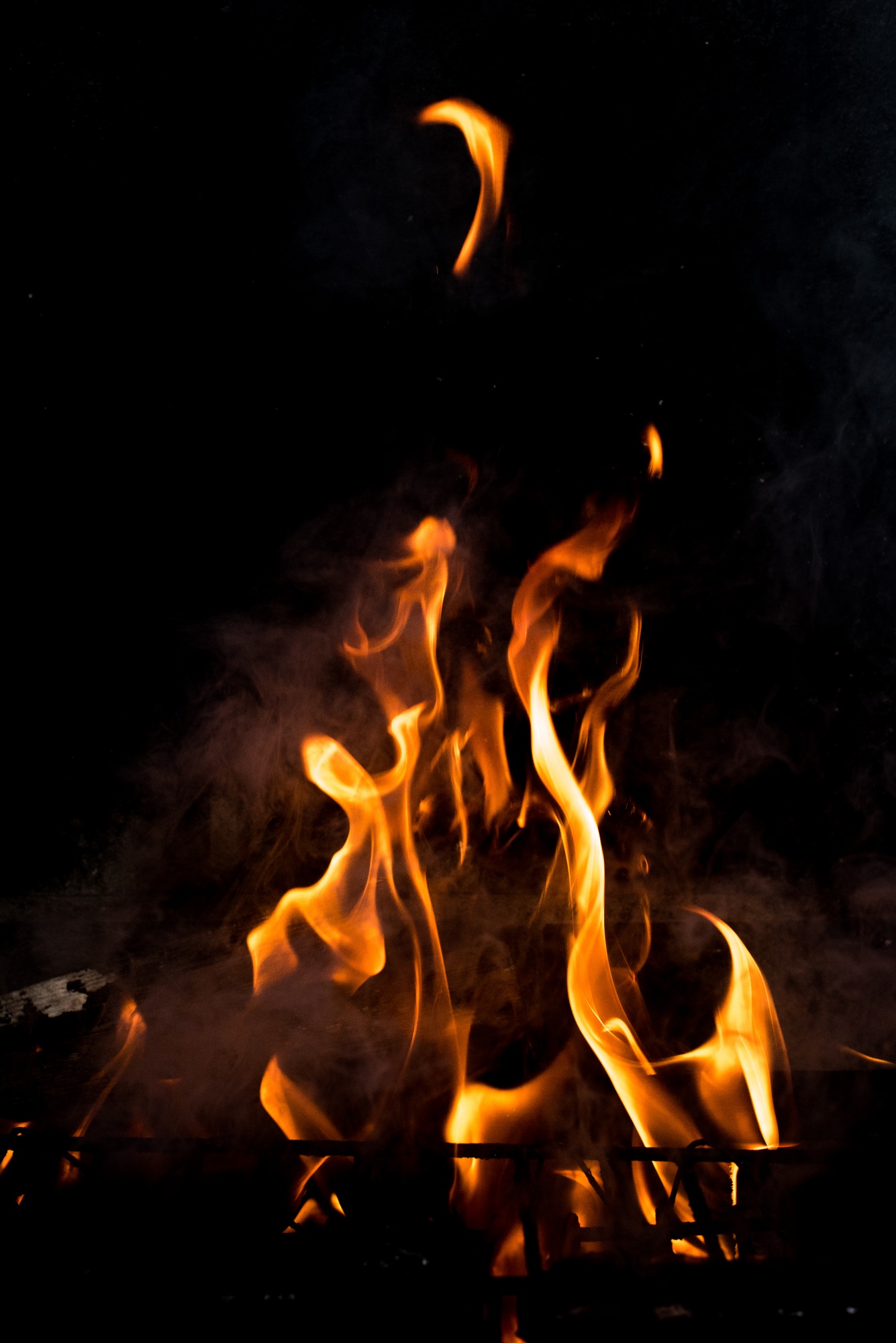 Flames in the fire of a red and yellow barbecue.